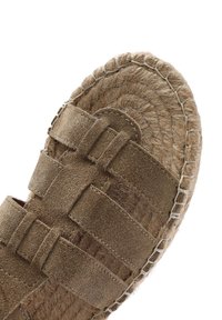 Sandal in suede marrone con suola in juta intrecciata. Presenta diverse cinghie e punta arrotondata, con texture contrastanti tra superfici lisce e ruvide.