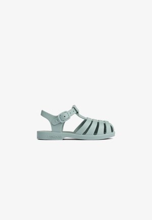 Light green sandal made of rubber, featuring a strap design with multiple cut-outs and an adjustable buckle on the side.