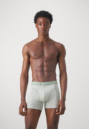 Grønne mønstrede boxershorts med tætsiddende design og elastisk talje, der viser "BJÖRN BORG" i lys grøn tekst.