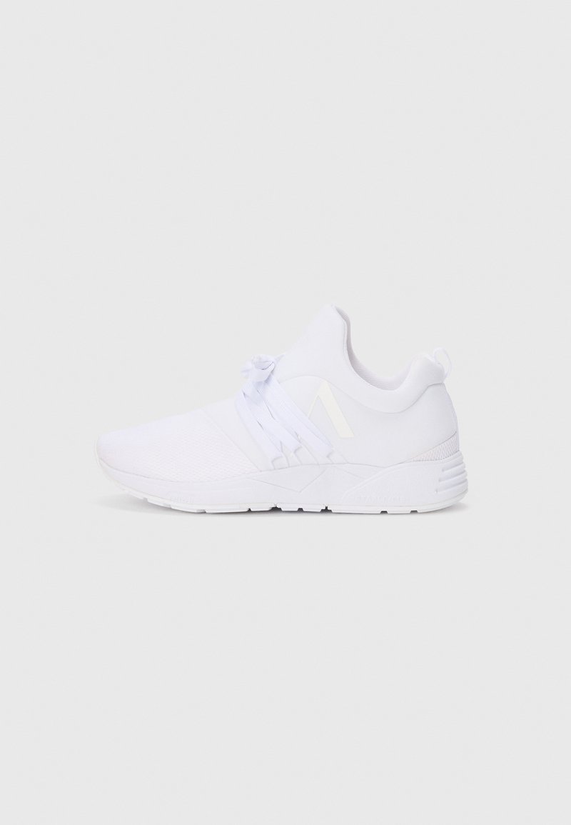 Baskets blanches de sport avec une tige en maille texturée, des lacets élastiques et une semelle courbée. Présente un branding subtil sur le côté et le talon.
