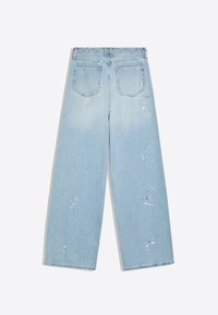Lichtblauwe jeans met wijde pijpen, twee achterzakken en subtiele witte verfspatten op de stof.