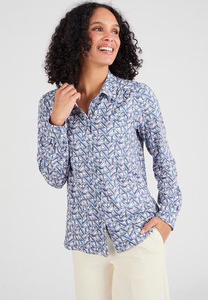 Chemise à manches longues à boutons de couleur bleue avec un motif géométrique en blanc, rose et marine. Tissu doux, coupe ajustée et col pointu.
