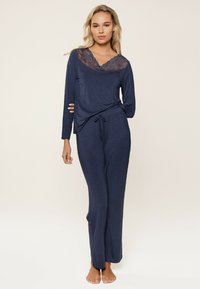 Marineblaues Schlafanzug-Set mit langen Ärmeln und Spitze am Ausschnitt, leichtem Stoff und verstellbarem Kordelzugbund. Glatte Textur und lange Hose.