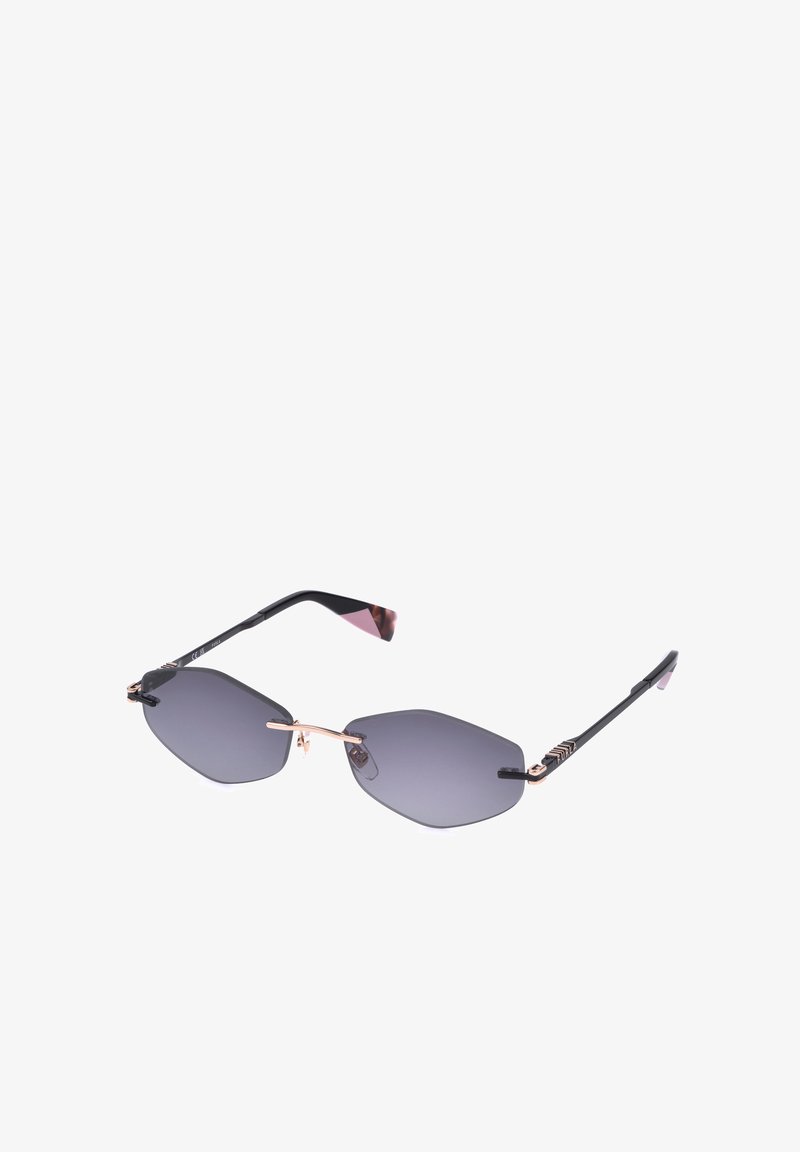 Lunettes de soleil sans monture avec des verres hexagonaux foncés, un pont fin en or et des branches noires avec des détails géométriques et des embouts roses.