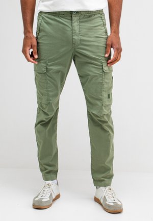 Groene cargobroek met een elastische tailleband, voorzien van zijzakken en enkelmanchetten. Gemaakt van lichtgewicht stof met een gladde textuur.