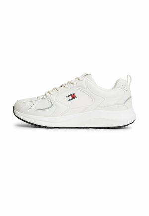 Hvid lav-sneaker med snørebånd foran, tyk sål og lille rød, hvid og blå Tommy Jeans-logo på siden.