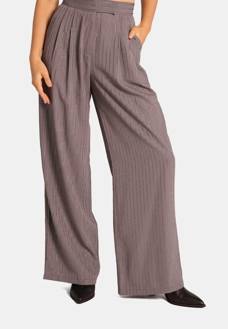 Pantalons à pattes larges dans une couleur mauve douce avec des rayures verticales et un léger scintillement. Dotés d'une taille haute et de poches latérales.