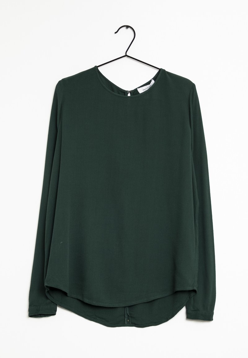 Blusa verde a maniche lunghe su una gruccia nera, con scollatura rotonda, texture liscia e orlo curvato con un sottile dettaglio di bottone nella parte inferiore.