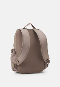 Mochila marrón con espalda de malla y correas acolchadas, bolsillo lateral con cremallera y tela suave, con una forma redondeada y herrajes ajustables.