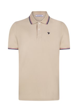 Beige kortærmet polo med to knapper, marineblå og røde stribede krave- og ærmekanter, og lille mørk fuglelogo på venstre bryst.
