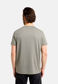 Sivé bavlnené tričko s okrúhlym výstrihom a krátkymi rukávmi, s rovnými lemami bez viditeľných vzorov alebo doplnkov.