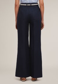 Marina vida byxor med breda ben, tillverkade av mjuk bomullsblandning, med hög midja, bakfickor och en klassisk design.