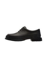 Chaussures en caoutchouc noires au design bas, à bout rond et à semelle rainurée proéminente, avec cinq œillets pour les lacets. Surface lisse et texturée.