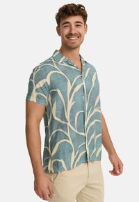 Short-sleeve button-up shirt with a turquoise and cream leaf pattern, made of lightweight fabric, featuring a collared neck and relaxed fit.