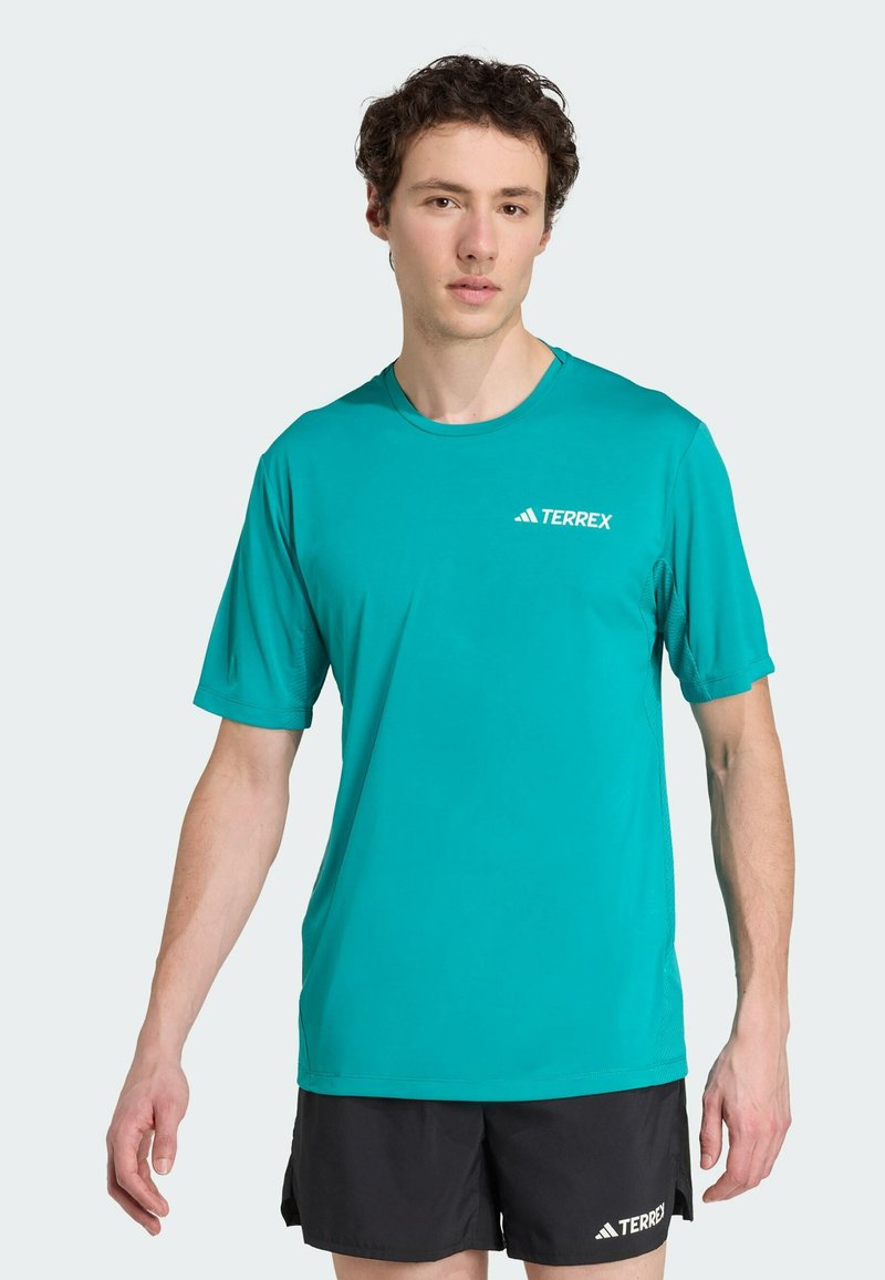 Turkos tränings-t-shirt i lätt tyg, med rund halsringning, korta ärmar och subtil "TERREX"-logotyp på bröstet.