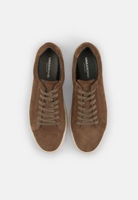 Zapatillas de ante marrón con puntera redonda, diseño de cordones planos y suela de goma de color claro. El interior presenta una plantilla negra de marca.