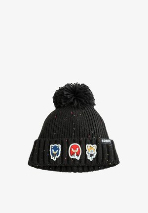 Sort strikbeanie med en pom-pom på toppen, der har tre farverige karakterlapper og prikker af farve fordelt over stoffet.