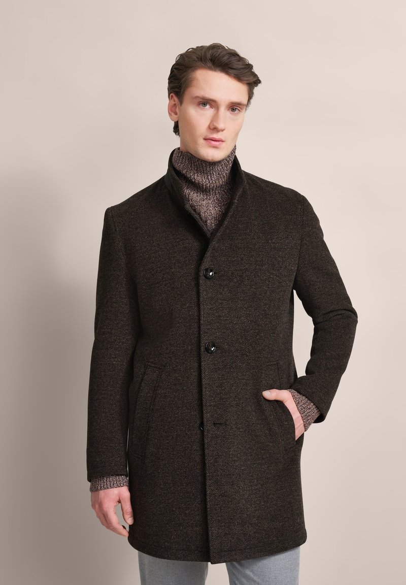 Dark brown wool coat with a high collar, featuring black buttons, two side pockets, and a textured sweater underneath.