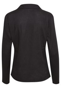 Chemise noire à manches longues avec col et boutons, vue de dos, avec un ourlet légèrement incurvé.