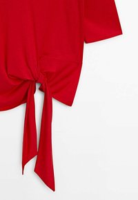 Haut en mélange coton rouge avec un détail noué à l'avant. Manches courtes et coupe décontractée. Texture lisse avec un design légèrement drapé.