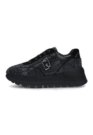 Zapatilla negra con suela gruesa y detalles de pedrería brillante por toda la superficie, con un logo decorativo plateado en el lateral.