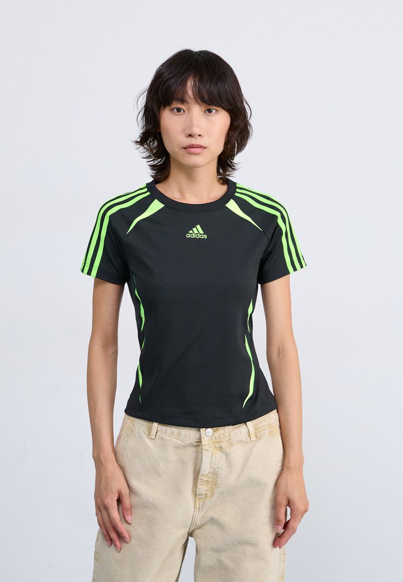 Schwarzes Sport-T-Shirt mit leuchtend grünen Akzenten und Streifen auf den Schultern, kurzen Ärmeln, rundem Ausschnitt und taillierter Passform.
