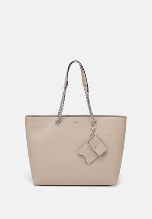 Sac fourre-tout en cuir beige avec anses en chaîne argentée et pochette assortie attachée à fermeture éclair, présenté sur fond blanc.