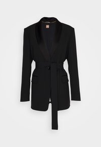 Blazer noir à manches longues avec col châle en satin, ceinture à la taille, fermeture par boutons et deux poches à rabat sur le devant.