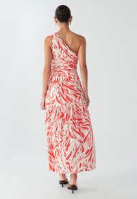 Ühe õlaga kreemikas maksikleidi punase abstraktse trükiga. Omadused: kogutud talje ja kihiline ääris. Sile kangas pehme tekstuuriga.