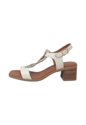 Sandalo aperto in pelle bianca con cinturino alla caviglia, fibbia dorata, design a T-strap, sottopiede imbottito marrone e tacco basso a blocco in legno impilato.
