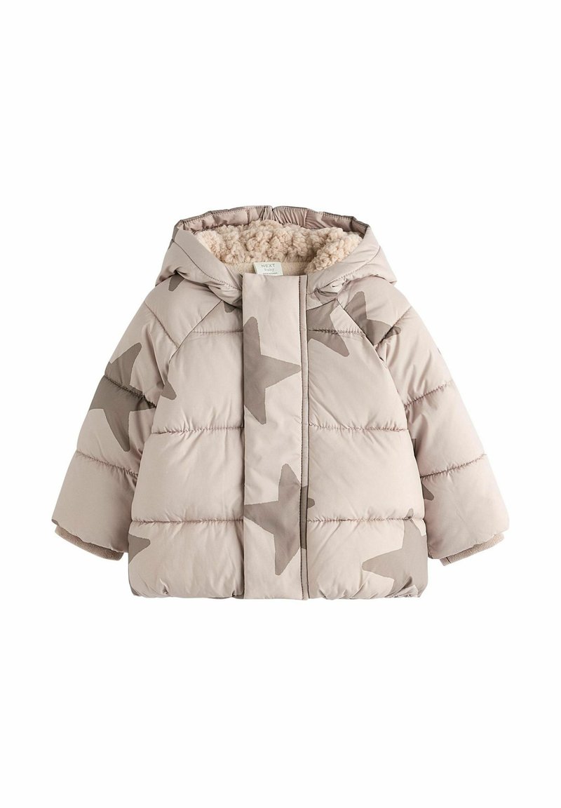Beige takki, jossa on pehmeä ja pörröinen vuori. Siinä on suuria taupe-värisiä tähtikuvioita ja huppu. Lyhyet, leveät hihat ja joustavat hihansuut.