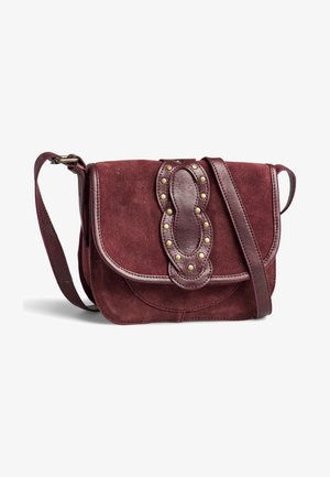 Petit sac bandoulière bordeaux en daim avec bandoulière en cuir et patte décorative en cuir ornée de clous en laiton sur le rabat avant.