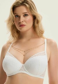 Biały koronkowy biustonosz z podszewką, regulowanymi ramiączkami, ozdobiony kwiatowymi wzorami i przezroczystymi koronkowymi akcentami. Złote warstwowe łańcuszki zdobią dekolt.