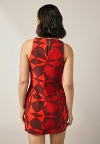 Rotes ärmelloses Kleid mit einem geometrischen Muster in verschiedenen Rottönen und Brauntönen, mit einem Schlüsselloch-Detail im Rücken und einer taillierten Silhouette.