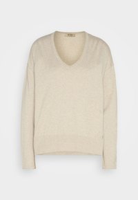Pull beige à manches longues avec col en V, ourlet et poignets côtelés, coupe ample, présenté sur un fond blanc.