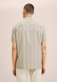 Camicetta a maniche corte di colore grigio chiaro con strisce verticali in beige, arancione e verde. Presenta un orlo dritto e un colletto classico.
