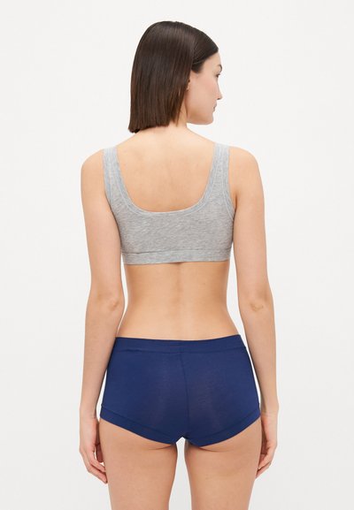 Gray cotton bralette with wide straps, paired with navy blue hipster shorts. Smooth texture with a comfortable fit. No visible logos.