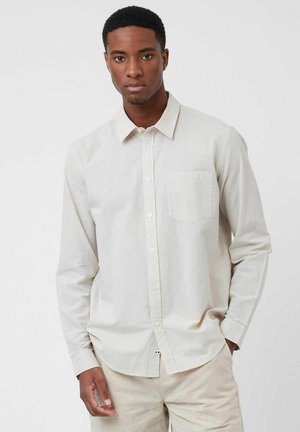 Light beige long-sleeve shirt in lightweight fabric, featuring a button-down collar, a chest pocket, and a rounded hem.