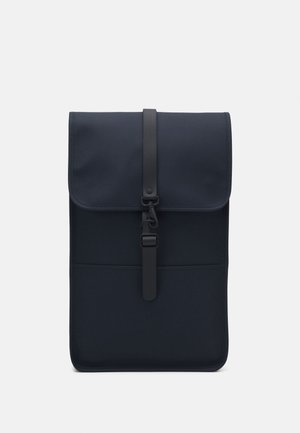 Sac à dos rectangulaire bleu foncé avec un rabat sécurisé par une sangle noire centrale et une fermeture à crochet, présenté sur un fond blanc uni.