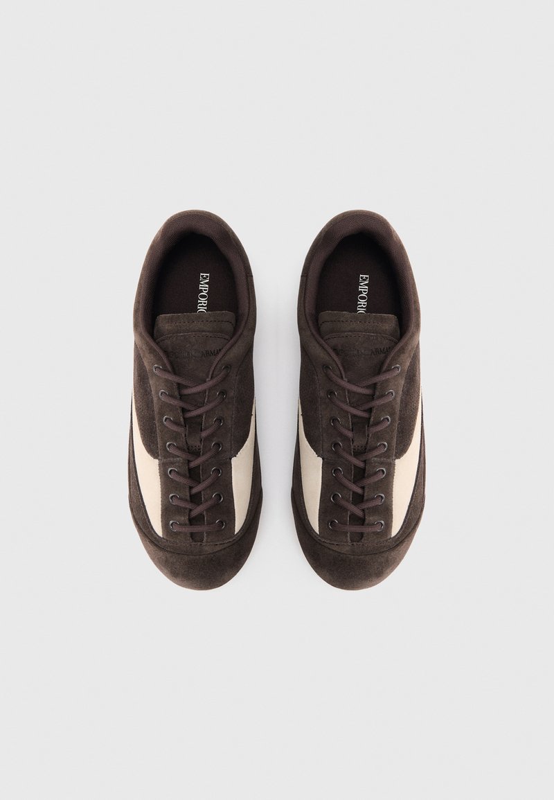 Sneaker in suede marrone con pannello laterale crema, punta rotonda e chiusura con lacci. Materiale testurizzato con imbottitura morbida e logo sulla soletta.