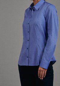 Blue button-down shirt in a textured fabric with long sleeves and a fitted shape. Features a classic collar and black buttons.