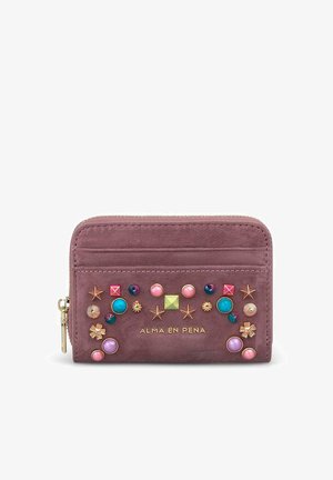 Pequeña cartera de ante malva decorada con tachuelas y estrellas de colores, cremallera dorada y nombre de la marca Alma en Pena en relieve en el frente.