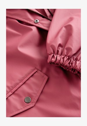 Rózsaszín vízálló dzseki, csillogó textúrával, rugalmas mandzsettákkal és patentos zsebbel. Cipzár az elején, sima kivitelben.
