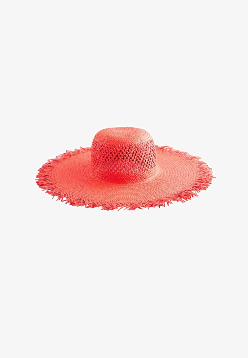 Coral-colored wide-brimmed hat made of woven material. Features a textured, open design with fringed edges along the brim.