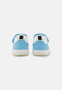 Scarpe sintetiche blu con dettagli in tessuto bianco, dotate di cinturini in Velcro, un'etichetta nera sul tallone e una suola in gomma testurizzata.