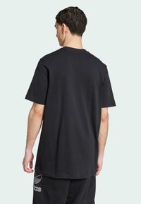 T-shirt nera in cotone con maniche corte, vestibilità rilassata e collo a giro. Design semplice, senza pattern o accenti visibili.