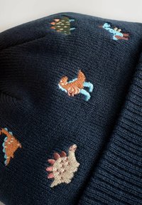 Marineblau gestrickter Stoff mit bunten Dinosauriermotiven, die über die Oberfläche verteilt sind.