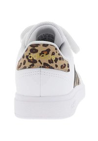 Sneaker bianca con pannello in stampa leopardata sul tallone, caratterizzata da strisce nere e un logo dorato. Texture liscia, fodera interna morbida.