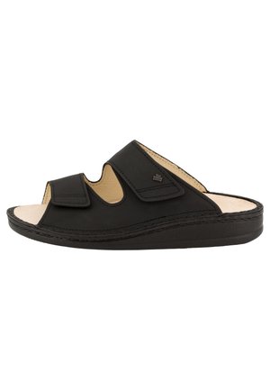 Zwarte lederen open teen slippers met twee verstelbare riemen en een gevoerde beige voetbed, lage plateauzool.