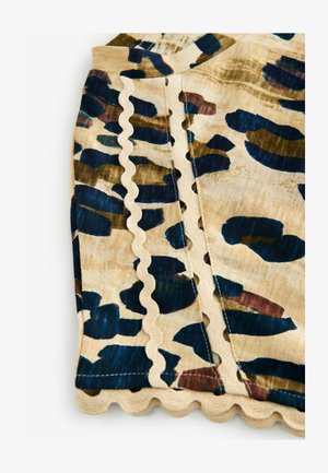 Beige stof met een kleurrijke luipaardprint in marineblauw, groen en bordeauxrood; heeft geschulpte randen en gestikte details langs de naden.